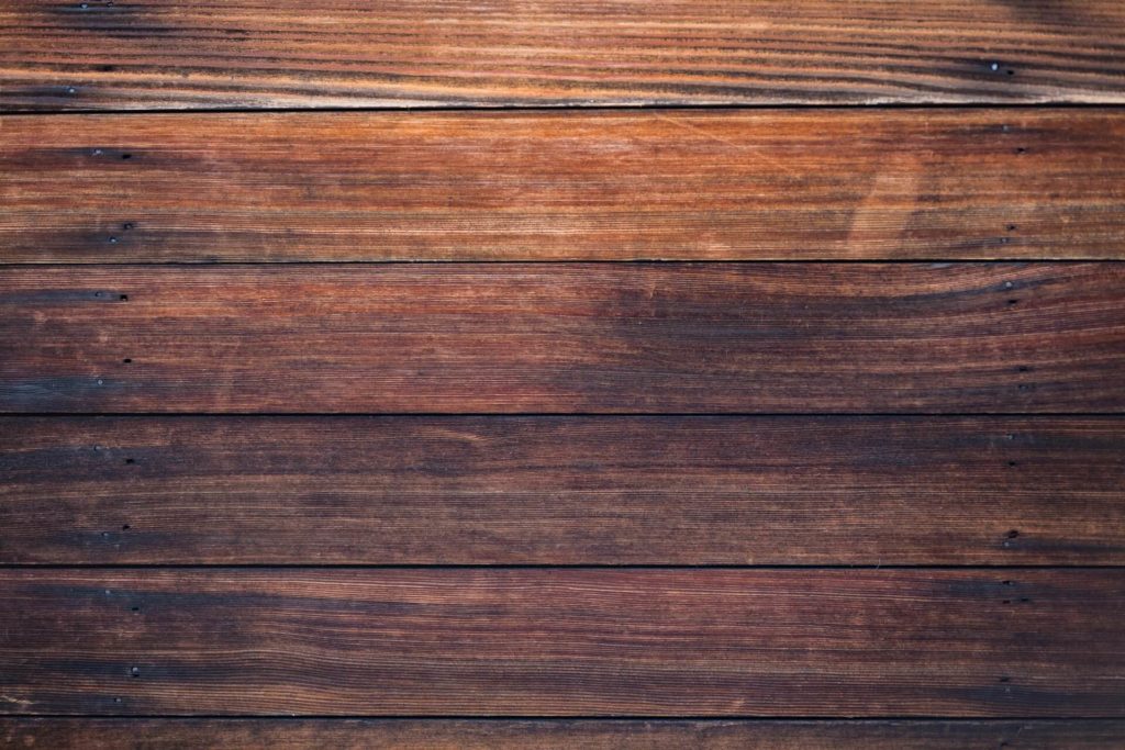 Weathered wooden floorboards viewed from directly above (Photo by Jon Moore on Unsplash)