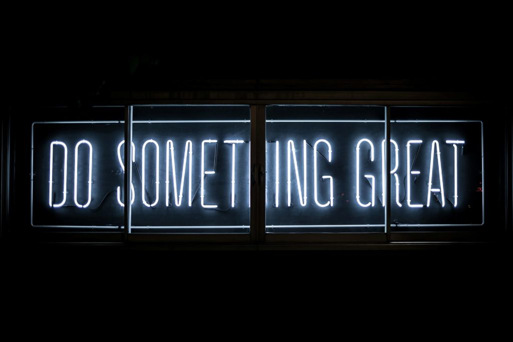 A bright blue neon sign reads "do something great" (Photo by Clark Tibbs on Unsplash)