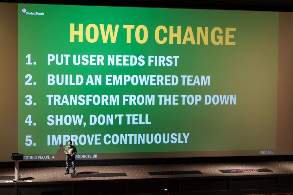 Jock Busuttil presents his talk "Digital Justice" in front of a cinema screen at Product Management Festival 2015 (Photo by Product Management Festival)