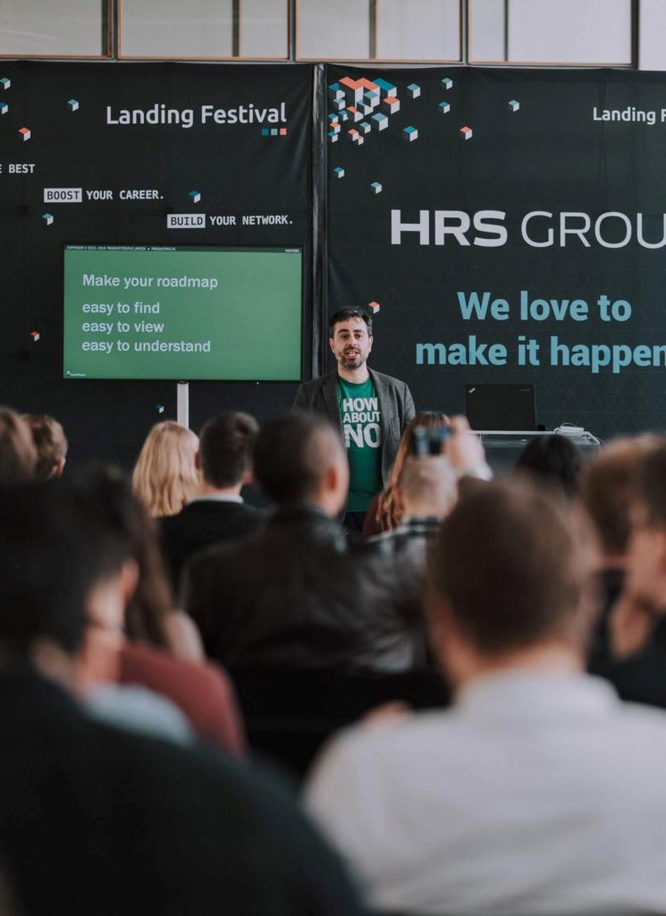 Jock Busuttil standing in front of a screen while giving his talk "The Secrets of Meaningful Roadmaps" at Landing Festival 2019 (Photo by Landing Jobs)